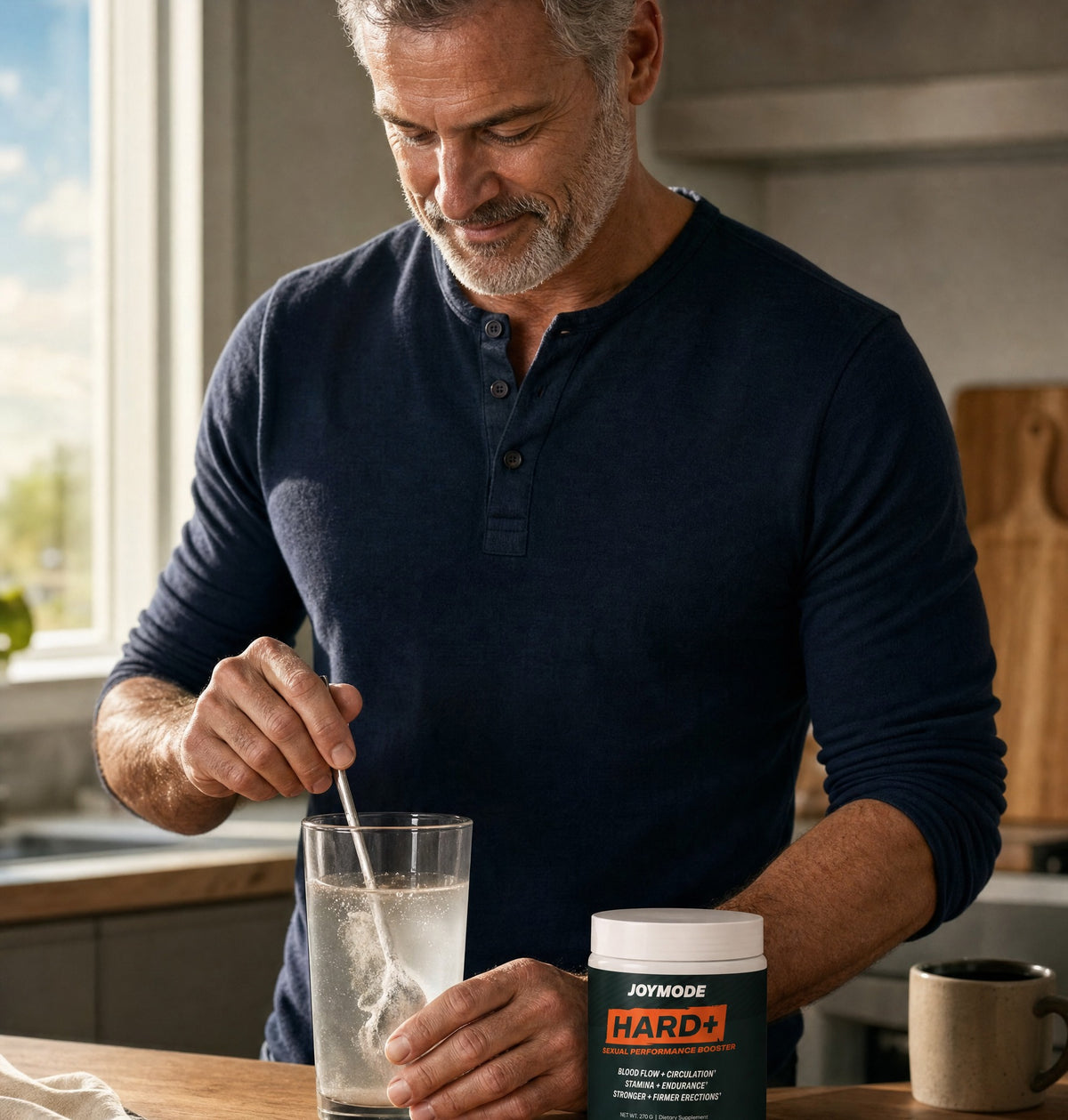 Man stirring Hard+ into a glass of water at his kitchen counter